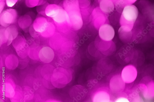 Blurry purple background with defocused bokeh circles from a Christmas garland photo
