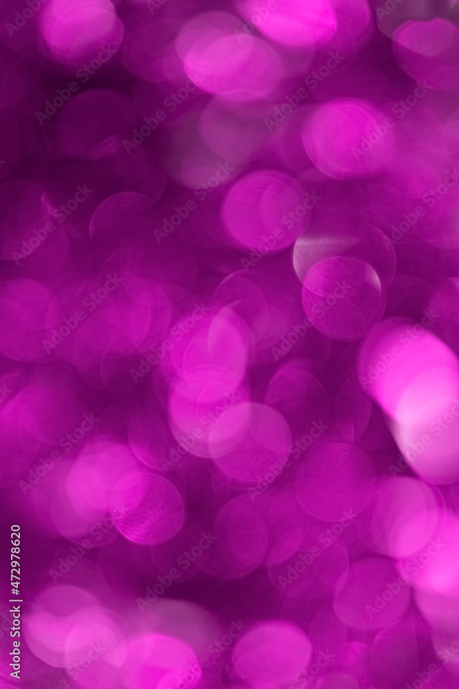 Blurred purple background with defocused bokeh circles from a Christmas garland vertical orientation Blurred purple background with defocused bokeh circles from a Christmas garland vertical orientation