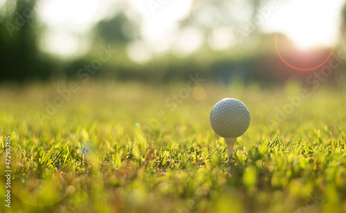 Golf ball on tee ready to be shot- wide landscape as background Ready