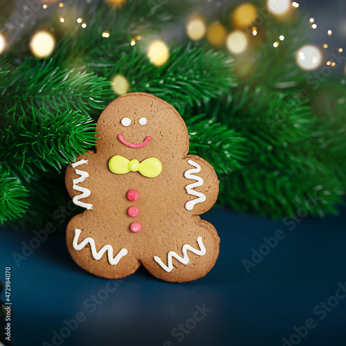 Blurred Christmas decoration with tree branches and gingerbread man on Blue background. New Year concept.