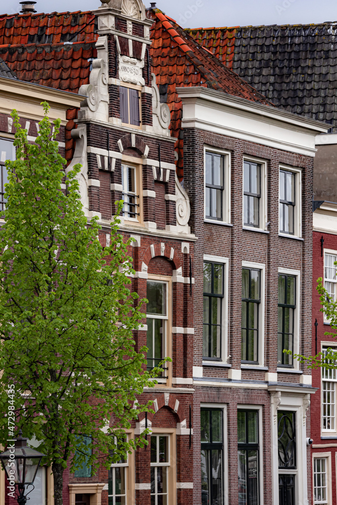 Fototapeta premium Beautiful and quaint street view with old buildings and greenery in spring in Leiden, Netherlands