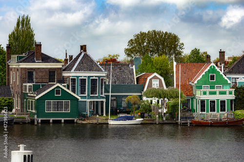 Beautiful small houses by the water with windmills in Zaanse Schans, Netherlands