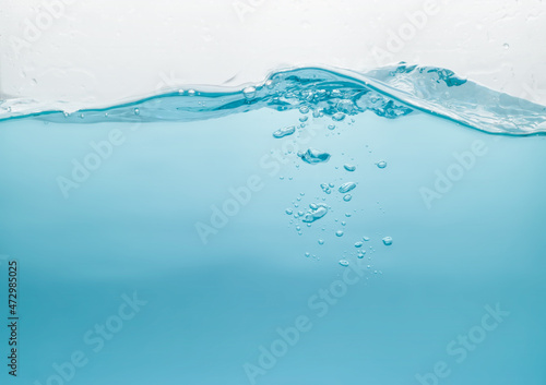 Water waves splash with air bubbles, isolated on the white background. abstract blue water waves on a white background. for a product, advertising,text space