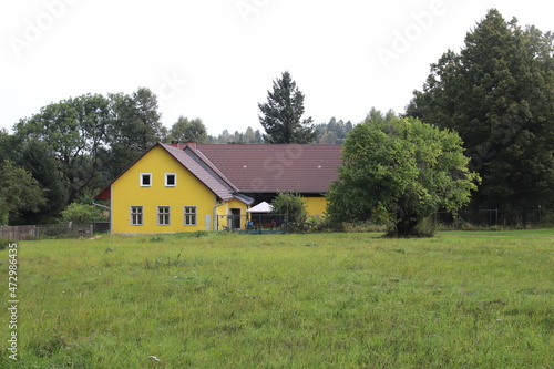 A yellow house in the countryside surrounded by trees at Nova Bystrice, Czech republic 