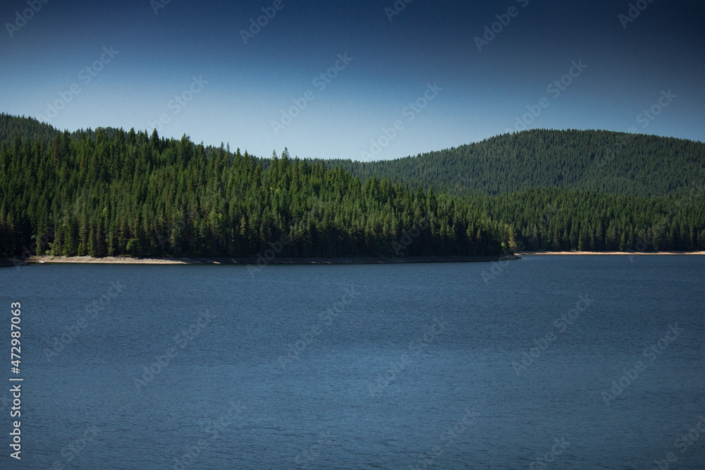 Lake with deep blue sky and water in clear summer day with greenery