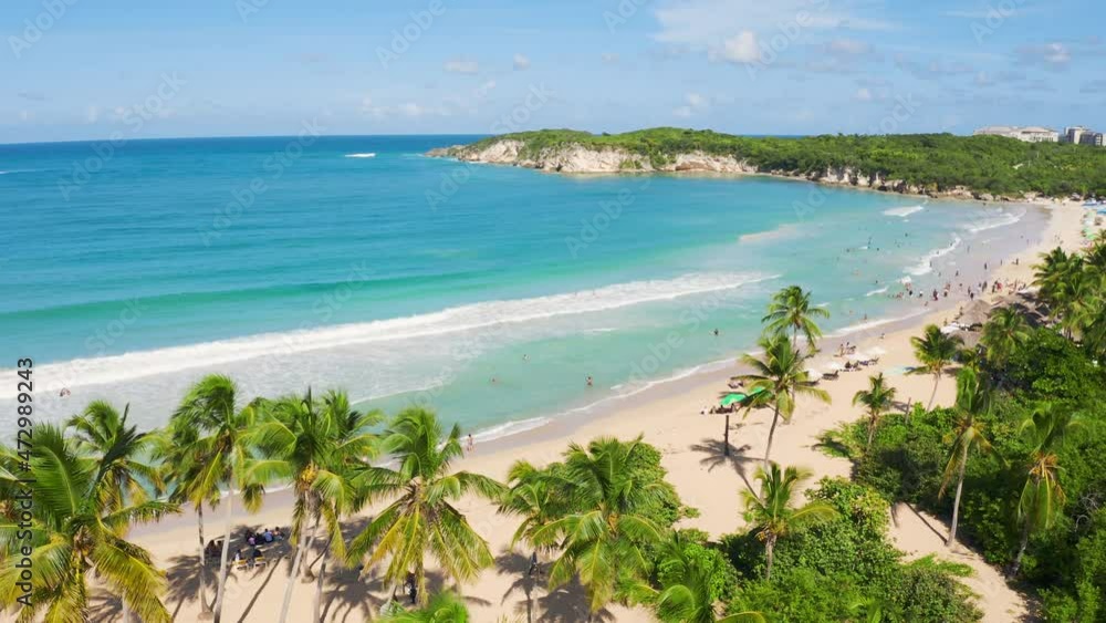Travel to the wild palm beach of Macau in Punta Cana in the Dominican Republic. White sand and tall coconut trees at the edge of the blue ocean. Summer morning landscape on the paradise island. Travel to the wild palm beach of Macau in Punta Cana in the Dominican Republic. White sand and tall coconut trees at the edge of the blue ocean. Summer morning landscape on the paradise island.