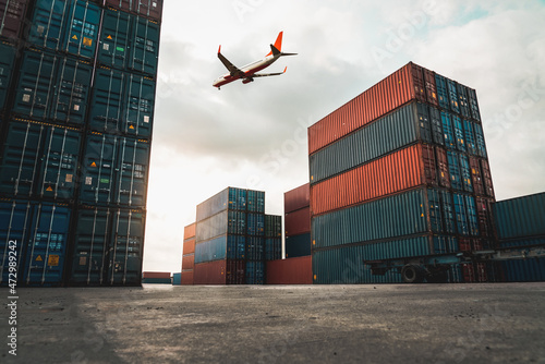 Freight airplane flying above overseas shipping container . Logistics supply chain management and international goods export concept . photo