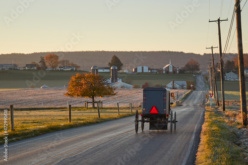 An Amish Horse and buggy on a country road at dawn,  Amish Country, Churchtown, Lancaster County, Pennsylvania, USA