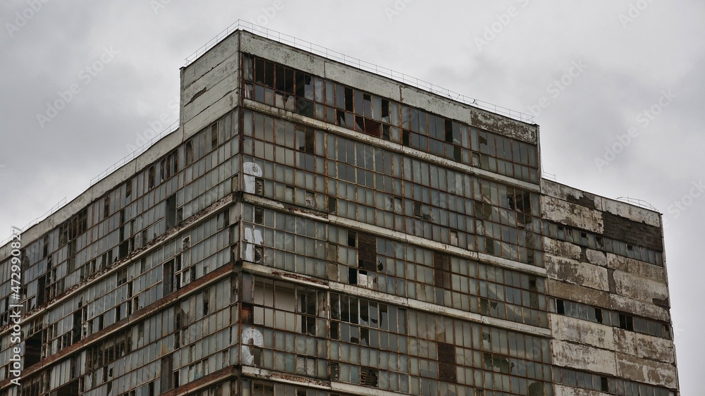 old industrial abandoned building with broken windows against the sky close-up old industrial abandoned building with broken windows against the sky close-up