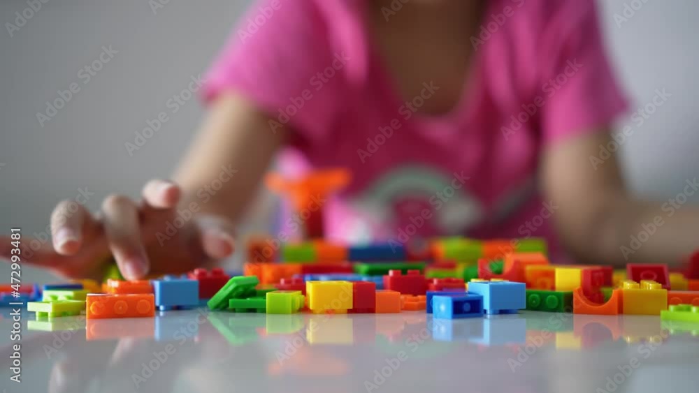 Close up the colorful plastic toy block. Background is hand of little girl play Close up the colorful plastic toy block. Background is hand of little girl play