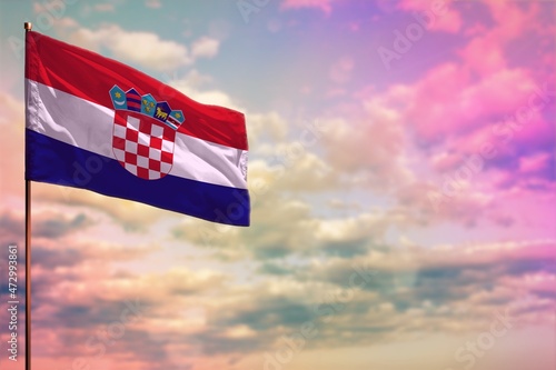 Fluttering Croatia flag mockup with the space for your content on colorful cloudy sky background. photo