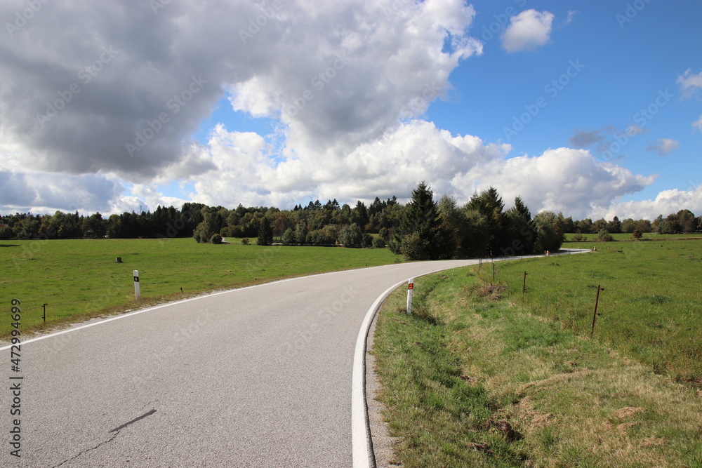 A beautiful wide road in the landscape with blue sky and clouds above near Kaproun, Czech republic A beautiful wide road in the landscape with blue sky and clouds above near Kaproun, Czech republic