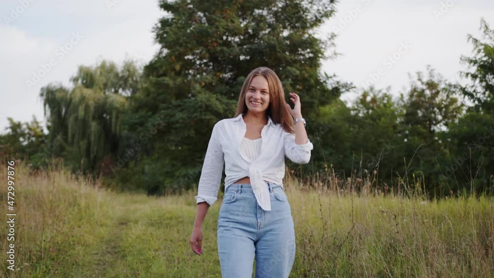 Attractive and cheerful teen girl walks in nature landscape. Sincere smiling and walking outdoors. Attractive and cheerful teen girl walks in nature landscape. Sincere smiling and walking outdoors.