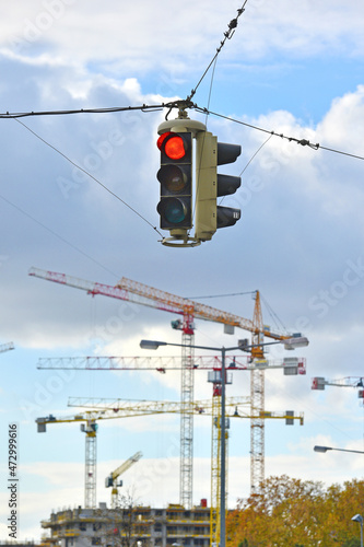 Baukräne auf einer Baustelle in Wien mit roter Ampel im Vordergrund photo