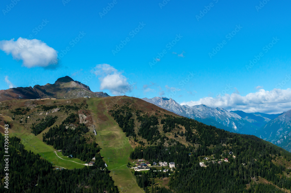 Fototapeta premium Bergige Landschaft in Österreich. Blick von einem hochgelegenen Punkt auf eine Gebirgskette. Sonniger Herbsttag