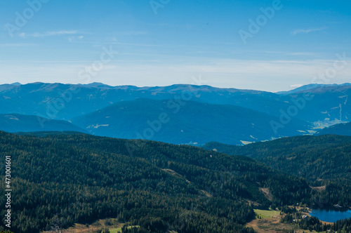 Fototapeta Naklejka Na Ścianę i Meble -  Bergige Landschaft in Österreich.  Blick von einem hochgelegenen Punkt auf  eine Gebirgskette. Sonniger Herbsttag