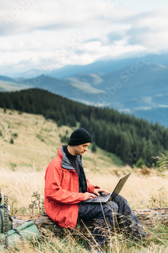 tourist freelancer in the mountains working online, laptop in travel for work, internet technologies for tourism, freelance concept