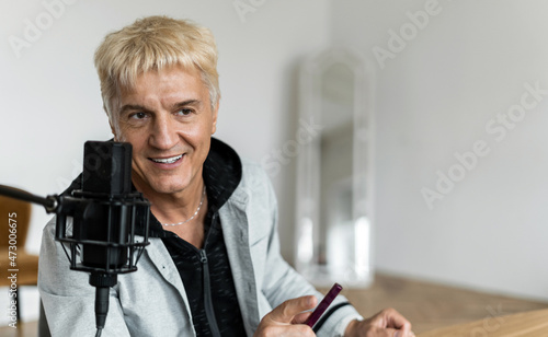 Portrait of a radio host pro age man working in a recording studio. Communicates with people through a microphone.