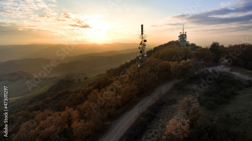 Canvas vista aerea delle antenne televisive su collina in stagione autunnale al tramont
