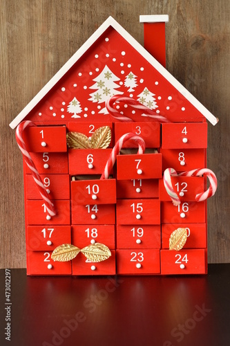 calendrier de l'avent sur fond en bois avec des sucre d'orge et des feuilles dorées