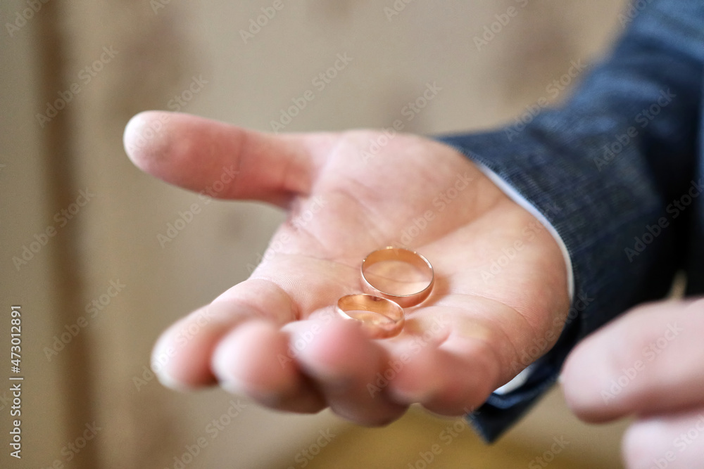 Golden wedding rings on the hand of the groom. Preparing for the wedding.