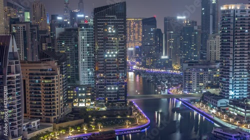 Wallpaper Mural Dubai Marina with several boat and yachts parked in harbor and skyscrapers around canal aerial all night timelapse. Torontodigital.ca