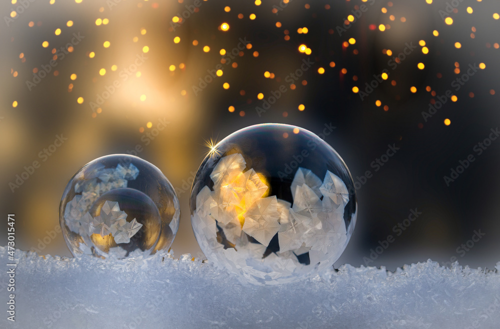 Christmas. Glowing frozen soap bubble with fireflies and golden background, copy space Christmas. Glowing frozen soap bubble with fireflies and golden background, copy space