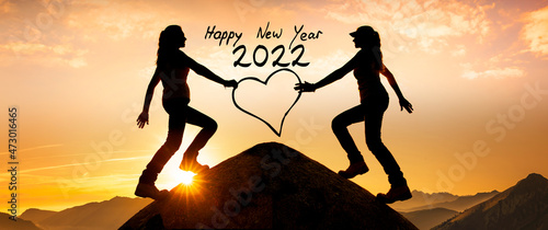 Silhouetten von zwei Frauen auf einem Gipfel zu Neujahr 2022