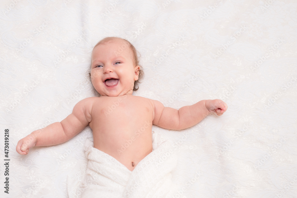 Laughing happy little baby lying on the bed Laughing happy little baby lying on the bed