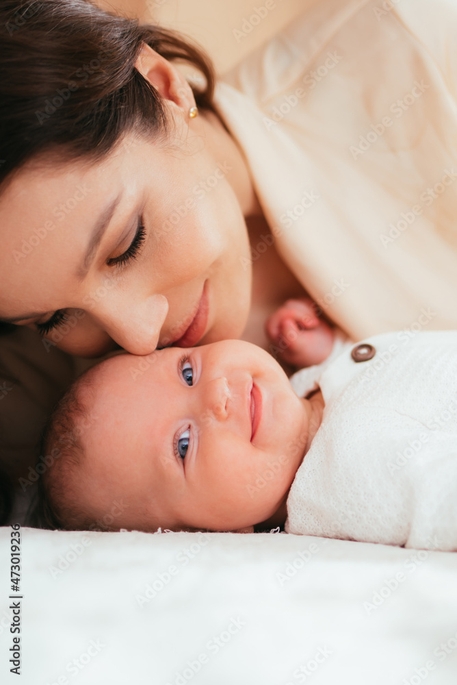 Beautiful mother kissing her little baby daughter Beautiful mother kissing her little baby daughter