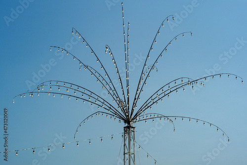 Many bulbs decorated on the steel branches in the shape of flower for local festival in Thailand isolated on blue sky background