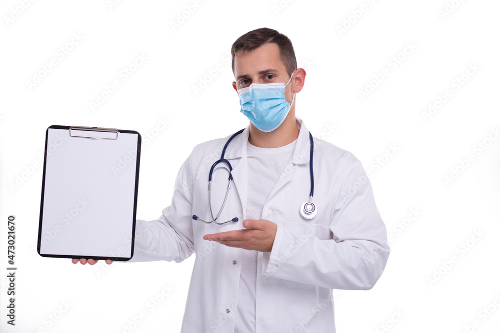 Doctor Man Showing Blank Clipboard Pointing at it Wearing Medical Mask Isolated. Advertisment, Office, Commercial Concept Doctor Man Showing Blank Clipboard Pointing at it Wearing Medical Mask Isolated. Advertisment, Office, Commercial Concept