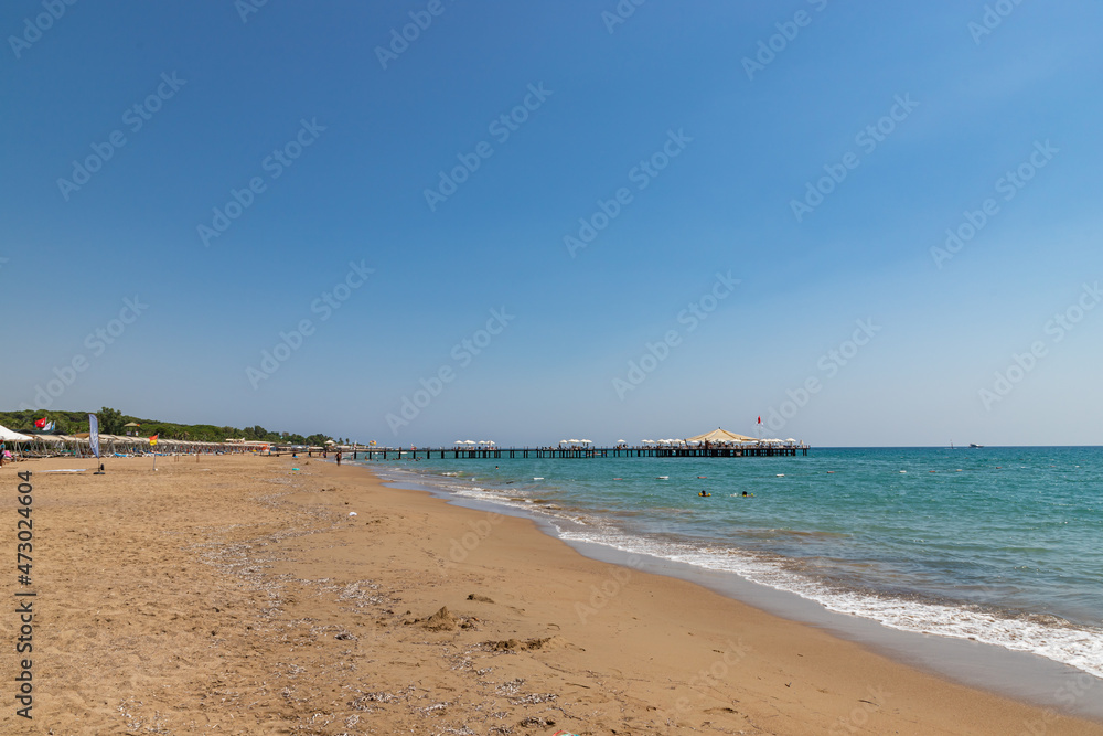SIDE, TURKEY - AUGUST 21, 2021: A beautiful, sandy beach in a tiny resort near Side. SIDE, TURKEY - AUGUST 21, 2021: A beautiful, sandy beach in a tiny resort near Side.