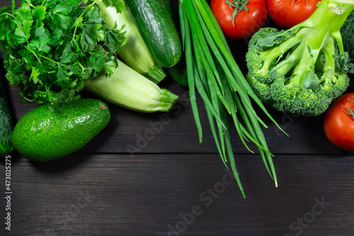 Fresh vegetables for cooking on a dark wooden background with space for text. Top view. Concept of healthy, vegetarian, diet food.
