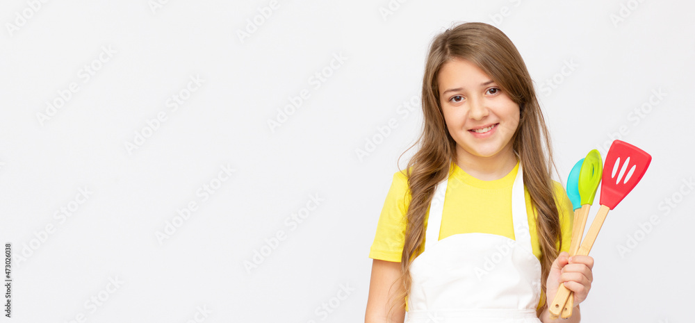 Teen happy girl chef cook confectioner baker housewife in yellow t shirt stay home isolated on light grey background studio. Food cook concept Teen happy girl chef cook confectioner baker housewife in yellow t shirt stay home isolated on light grey background studio. Food cook concept