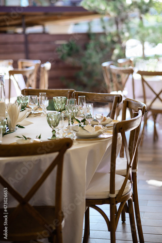 White table with tableware and chairs made of wood