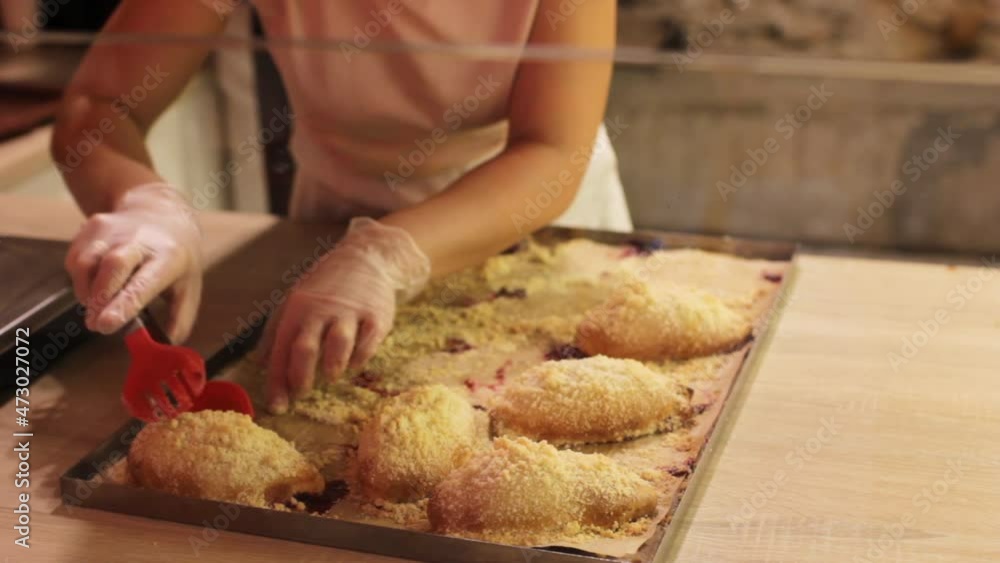 the cook girl opens ready-made buns with jam from pastry paper on a metal baking sheet. Production of buns. Bakery products. the cook girl opens ready-made buns with jam from pastry paper on a metal baking sheet. Production of buns. Bakery products.