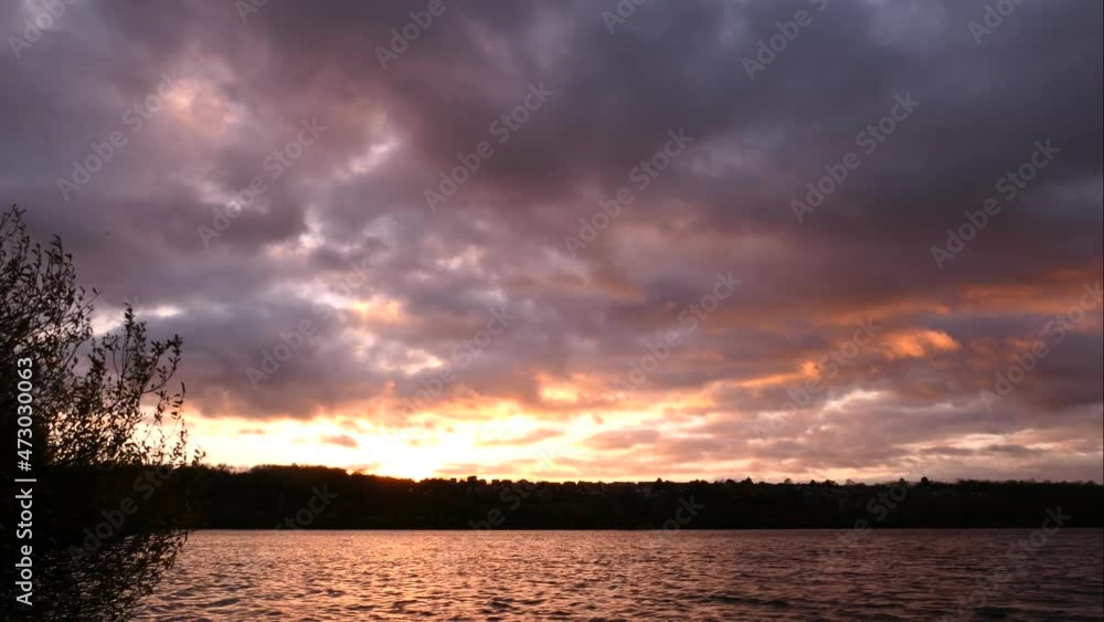 Cumulus clouds parade in the sky at sunset. Time lapse of a dramatic sky over the water. Cumulus clouds parade in the sky at sunset. Time lapse of a dramatic sky over the water.