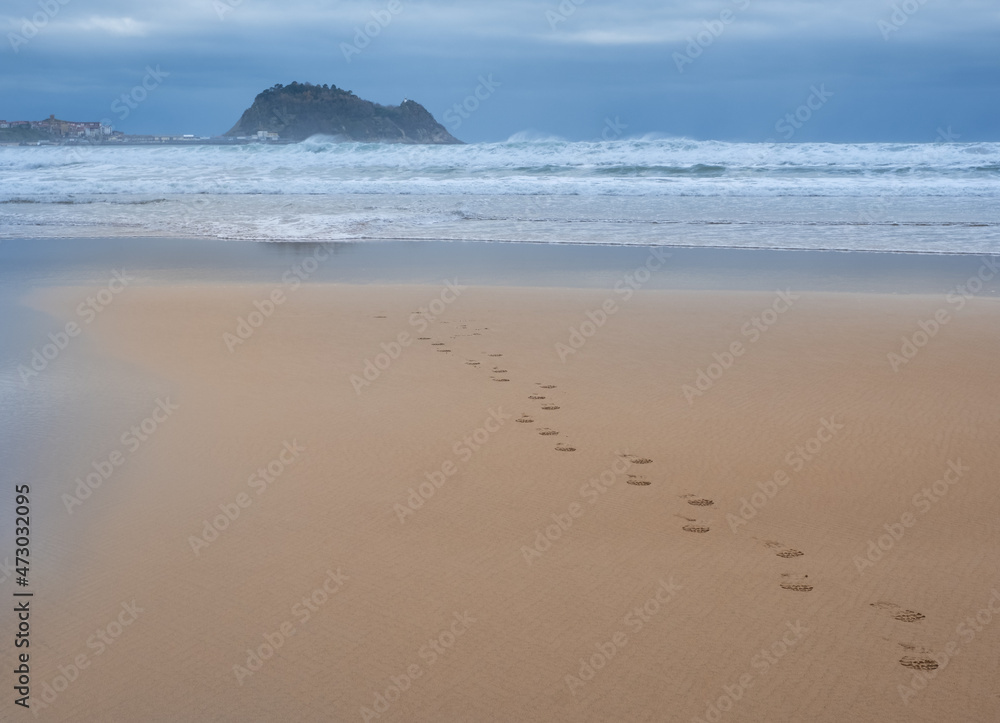 Footprints in the sand on the beach of Zarautz with Getaria in the background, Euskadi Footprints in the sand on the beach of Zarautz with Getaria in the background, Euskadi