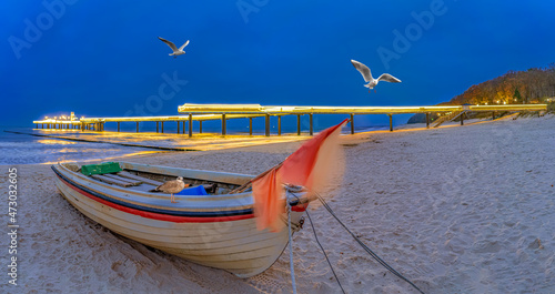 Fototapeta Naklejka Na Ścianę i Meble -  Ostsee,  wunderschöne Seebrücke Koserow auf der Insel Usedom bei Nacht mit Fischerboot im Vordergrund