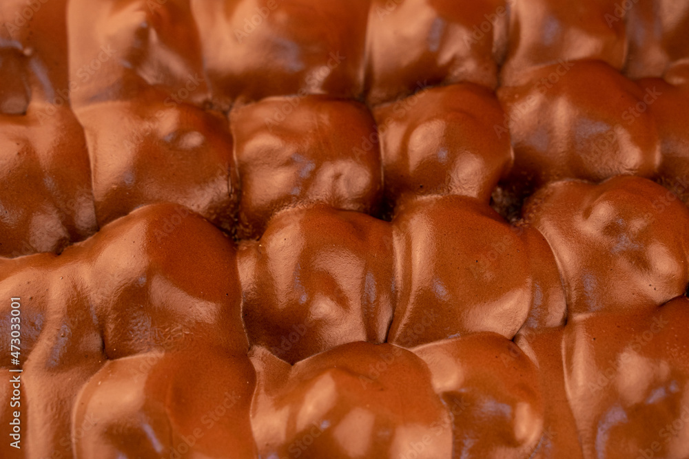 The texture of chocolate profiteroles. Close-up of a profiterole. chocolate coating. Traditional italian dessert profiteroles with chocolate cream The texture of chocolate profiteroles. Close-up of a profiterole. chocolate coating. Traditional italian dessert profiteroles with chocolate cream