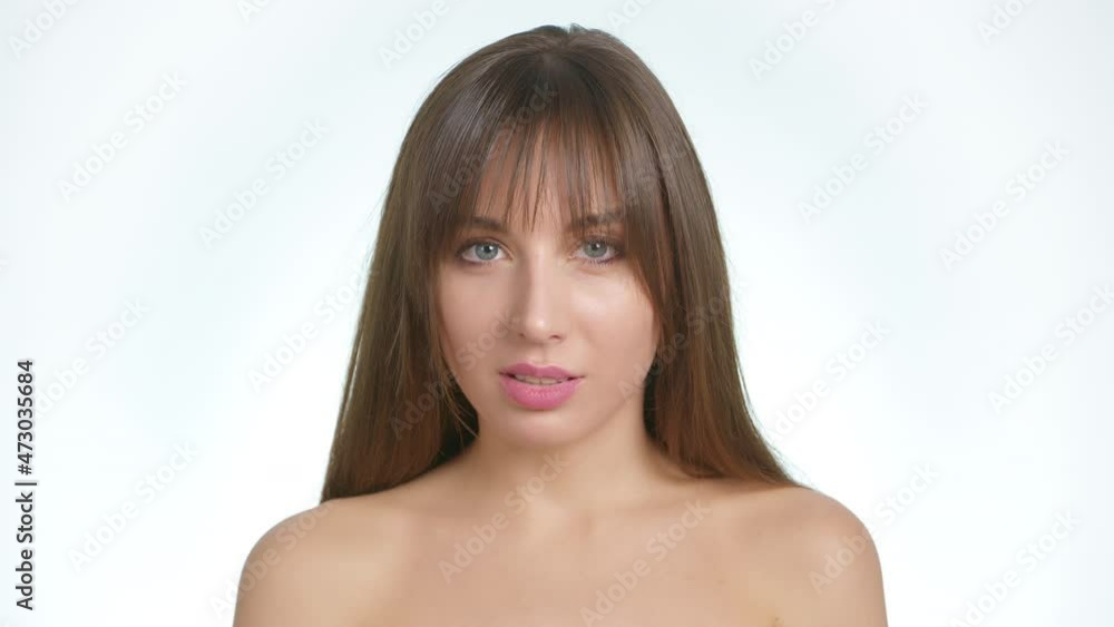 Portrait of a beautiful and sexy young woman with naked shoulders on a white background. Skin care concept. Portrait of a beautiful and sexy young woman with naked shoulders on a white background. Skin care concept.