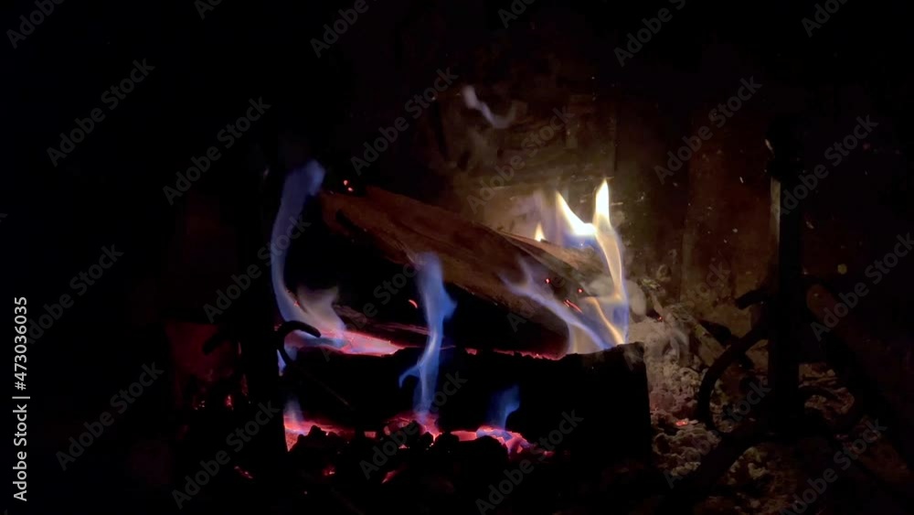 4k video with original sound. Close up shot of a fire starting in the fireplace, with yellow and blue flames. Flames flickering quickly in the darkness. Winter atmosphere mood. Smoke rising. 4k video with original sound. Close up shot of a fire starting in the fireplace, with yellow and blue flames. Flames flickering quickly in the darkness. Winter atmosphere mood. Smoke rising.
