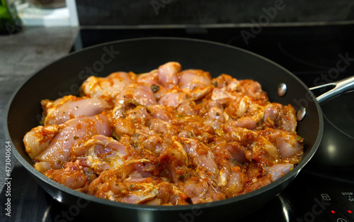 Raw chicken meat in frying pan. close up