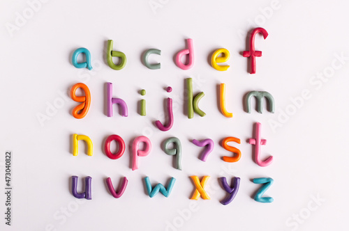letters of the English alphabet made of multicolored plasticine on a white background