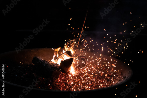 sprühende Funken und Holzasche in einer Feuerschale