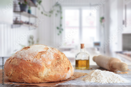 Fotografía freshly baked artisan bread in baking paper on table with ingredients and rollin