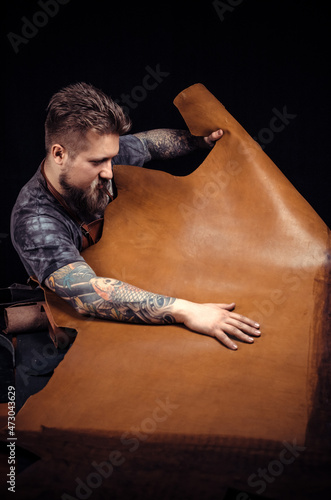 Artist working with leather works with leather photo
