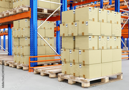 Warehouse Logistics. Logistic center with pallet racks. Cardboard boxes on wooden pallets. Logistics business concept. Distribution warehouse from inside. Nobody's storage space. photo