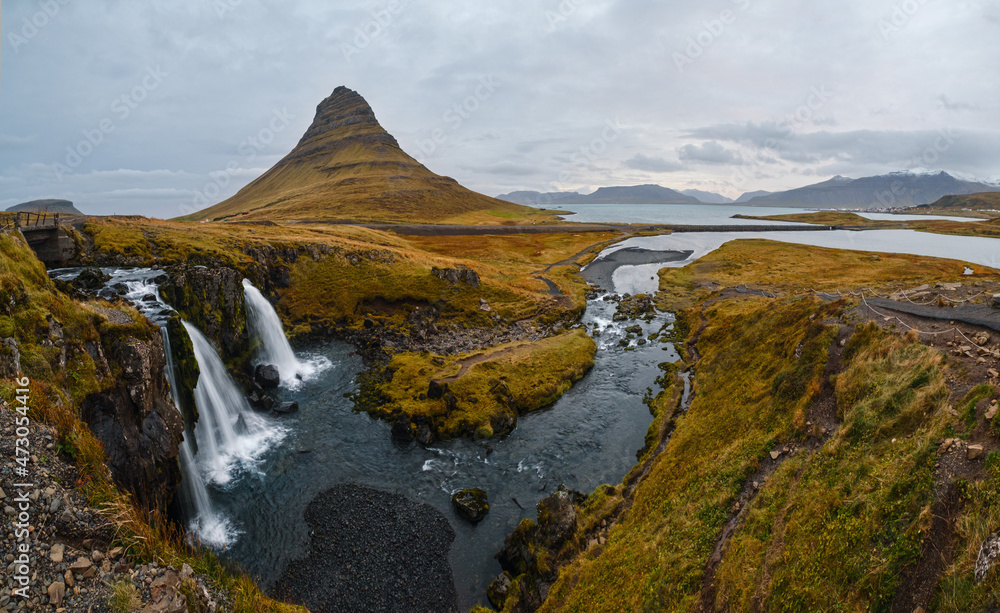 Famous picturesque Kirkjufell mountain and Kirkjufellsfoss waterfall next to Grundarfjörður at West Iceland autumn view.